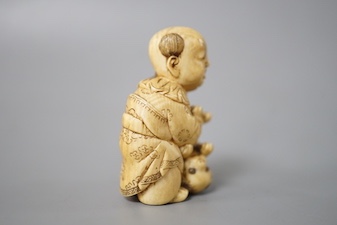 A Japanese ivory netsuke of boy and puppy, Meiji period, signed 4cm